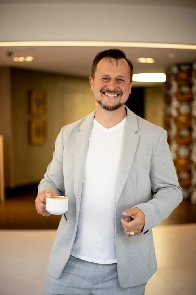 Alexis Santander sonriendo con una taza de café